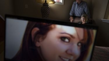 Sandy Phillips y su marido, Lonnie, posan para un retrato en casa de una amiga en Lone Tree, Colorado, el martes 5 de septiembre de 2023, detrás de una foto de su hija, Jessica Ghawi, que murió en la masacre de 2012 en un cine de Aurora, Colorado. Tras sufrir su propia pérdida personal, la pareja se propuso ayudar a otros padres en la misma situación que ellos, viajando a lugares de todo Estados Unidos donde han ocurrido tiroteos. El recorrido continuó durante una década. (AP Foto/David Goldman)