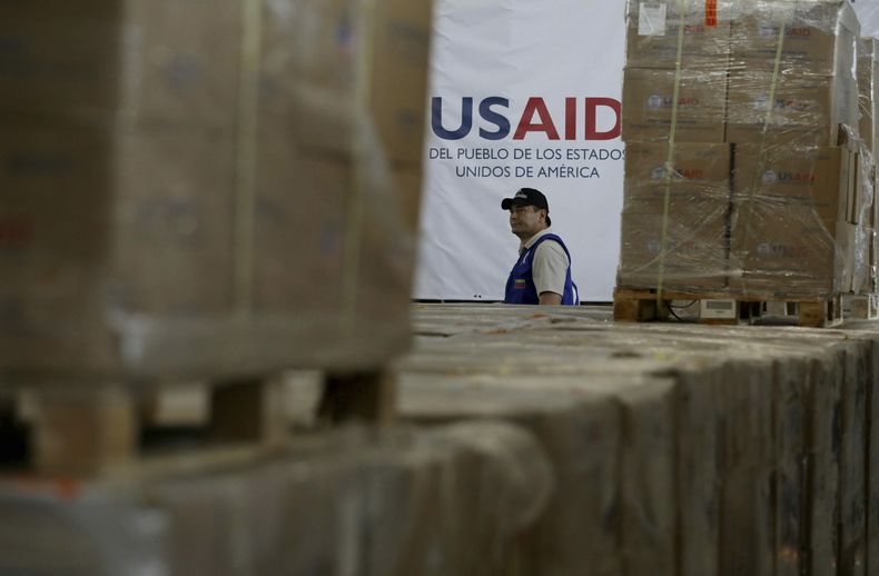 ARCHIVO – Un hombre camina junto a varias cajas de ayuda humanitaria de la USAID en un almacén de la Brigada Internacional Tienditas, en las afueras de Cúcuta, Colombia, el 21 de febrero de 2019, en la frontera con Venezuela. (AP Foto/Fernando Vergara, Archivo)