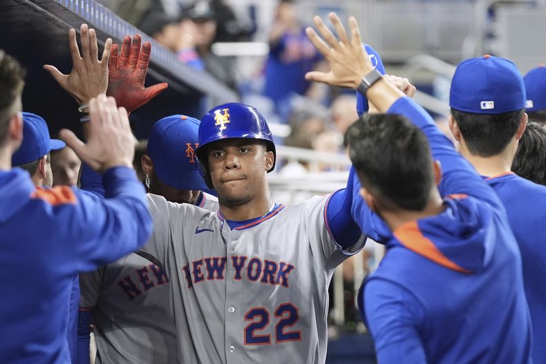 Juan Soto, de los Mets de Nueva York, es felicitado en la cueva tras anotar ante los Marlins de Miami, el miércoles 2 de abril de 2025 (AP Foto/Lynne Sladky)