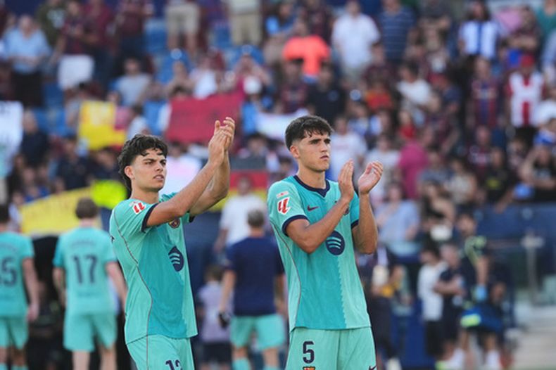 Xavi Espart y Pau Cubarsi del Barcelona saludan a la afición al final de la victoria ante el Levante en La Liga el domingo 13 de septiembre del 2026. (AP Foto/Alberto Saiz)