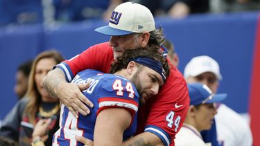 Cam Skattebo, corredor de los Giants de Nueva York, recibe un abrazo de su padre Leonard antes de un partido ante los Cardinals de Arizona, el domingo 4 de octubre de 2026 (AP Foto/Adam Hunger)