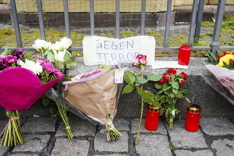 Velas, flores y un cartel con la inscripción Contra el terror en la escena del crimen en la plaza del mercado de Mannheim, Alemania, el día después del apuñalamiento en una manifestación antiislámica en la plaza del mercado de Mannheim en el que resultaron heridas seis personas, entre ellas un agente de policía, el sábado 1 de junio de 2024. (Uwe Anspach/dpa via AP)