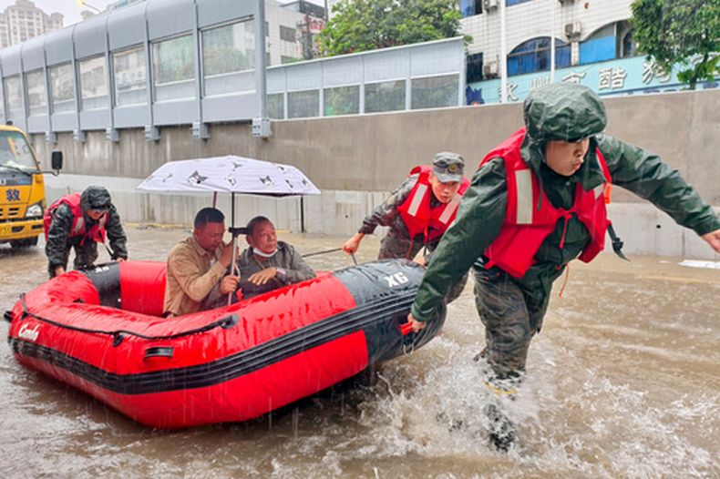 En esta foto publicada por la agencia de noticias Xinhua, residentes varados son evacuados en un bote durante una inundación tras fuertes lluvias en Qinzhou, en la Región Autónoma de Guangxi Zhuang, en el sur de China, el lunes 27 de abril de 2026. (Ao Shuaichang/Xinhua via AP)