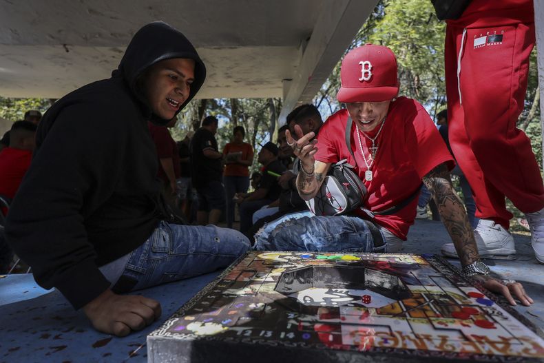 Varias personas juegan a la poleana, un juego de mesa inventado en prisión, antes de un torneo en Ciudad de México, el domingo 17 de noviembre de 2024. (AP foto/Ginnette Riquelme)