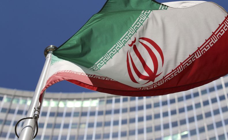 ARCHIVO - La bandera iraní ondea ante el edificio de Naciones Unidas, donde se celebran negociaciones nucleares a puerta cerrada en el Centro Internacional en Viena, Austria, el 18 de junio de 2014. (AP Foto/Ronald Zak, Archivo)