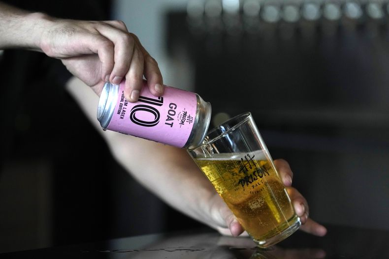 Un cantinero sirve una cerveza de Prison Pals Brewery, llamada GOAT 10 en honor del astro argentino del fútbol Lionel Messi, el martes 11 de julio de 2023, en Doral, Florida (AP Foto/Lynne Sladky)
