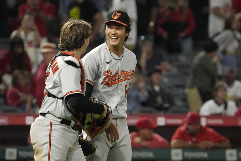 Shintaro Fujinami, relevista de los Orioles de Baltimore, festeja con el cátcher Adley Rutschman, al concluir el juego del martes 5 de septiembre de 2023, ante los Angelinos de Los Ángeles (AP Foto/Mark J. Terrill)