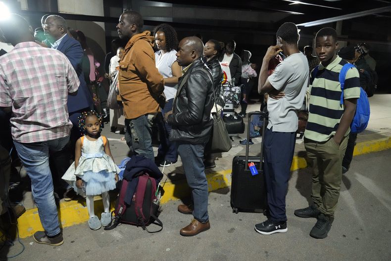 Zimbabuenses desalojados de Sudán llegan al aeropuerto internacional Robert Mugabe en Harare, Zimbabue, el viernes 28 de abril de 2023. (AP Foto/Tsvangirayi Mukwazhi)
