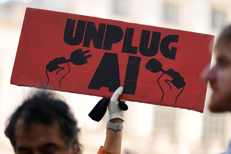 ARCHIVO - Un pequeño grupo de personas a favor de implementar restricciones a la inteligencia artificial sostiene pancartas frente al ayuntamiento de Nueva York el 5 de octubre de 2026, antes de una audiencia del Concejo Municipal sobre la seguridad de la IA en la ciudad. (AP Foto/Seth Wenig, archivo)