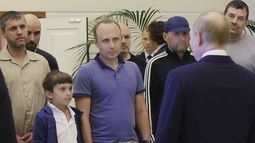 Un hombre identificado como Pablo González, periodista independiente de España que había vivido en Polonia desde 2019, segundo de izquierda derecha, con la cabeza rapada, escucha al presidente ruso Vladímir Putin, de espaldas a la cámara, hablando con prisioneros rusos liberados, como parte del mayor canje de prisioneros entre Estados Unidos y Rusia en la historia postsoviética, el jueves 1 de agosto de 2024. (Gavriil Grigorov, Sputnik, Kremlin Pool Foto vía AP)