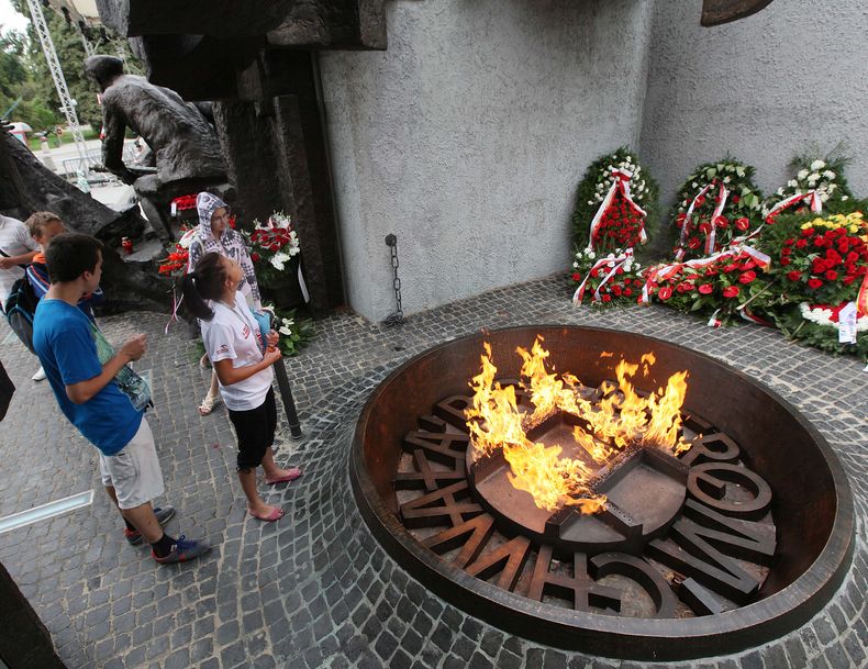 Algunas personas frente al monumento que conmemora el Levantamiento de Varsovia el 1 de agosto del 2014. Polonia record&oacute; ese d&iacute;a a los combatientes y las v&iacute;ctimas de una rebeli&oacute;n en 1944 contra los alemanes nazis depositando co