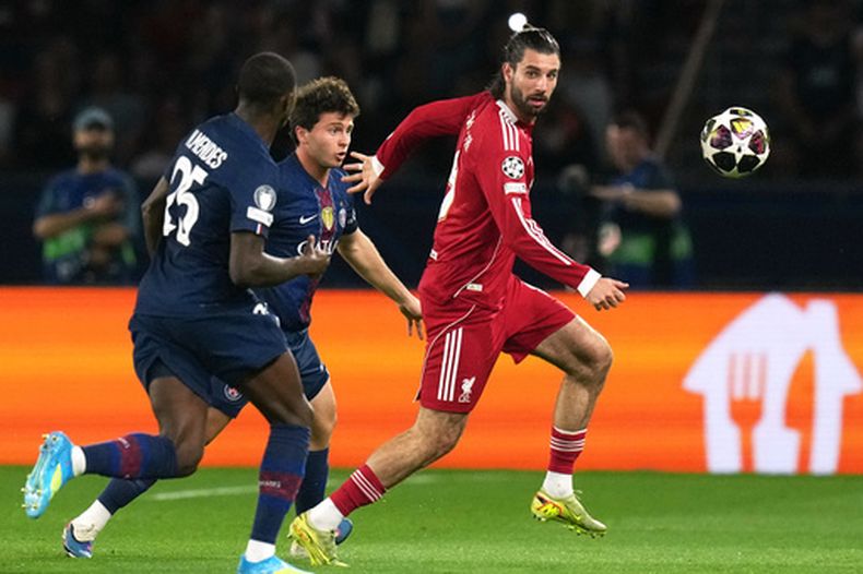 ARCHIVO - Dominik Szoboszlai, derecha, del Liverpool, disputa un balón con Joao Neves y Nuno Mendes, del PSG, durante los cuartos de final de la Liga de Campeones, el 8 de abril de 2026, en París. (AP Foto/Thibault Camus, Archivo)