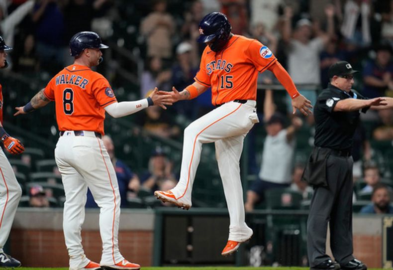Christian Walker (8) e Isaac Paredes (15), de los Astros de Houston, celebran las carreras anotadas con el triple productor de Cam Smith para tomar la ventaja en la octava entrada del partido de béisbol de Grandes Ligas contra los Piratas de Pittsburgh, el miércoles 3 de junio de 2026, en Houston. (AP Foto/Karen Warren)