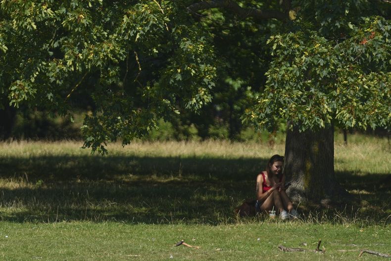 Una persona se resguarda del sol en Londres mientras partes del Reino Unido y el resto de Europa enfrentan una ola de calor, el lunes 11 de agosto de 2025. (AP Foto/Joanna Chan)