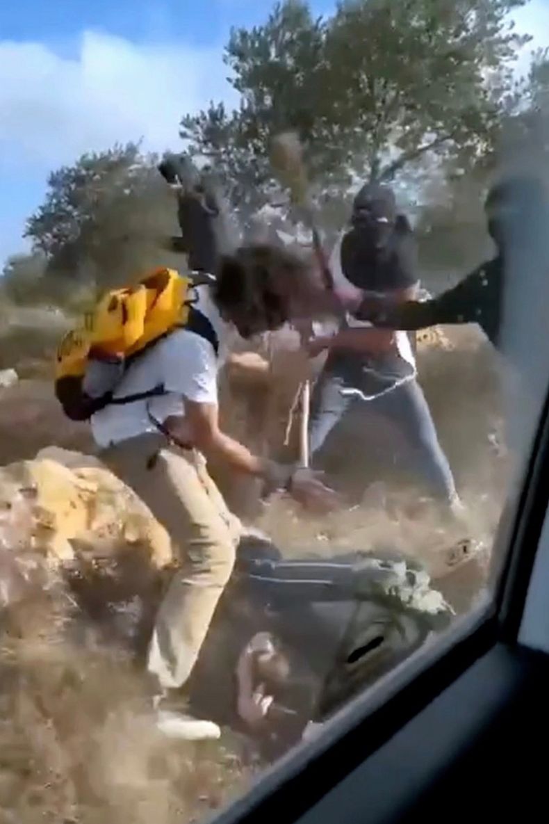 En esta imagen del 19 de octubre de 2025, tomada de un video, se muestra lo que parecen ser colonos enmascarados golpeando a activistas y agricultores palestinos en Turmus Ayya, Cisjordania. (AP Foto)