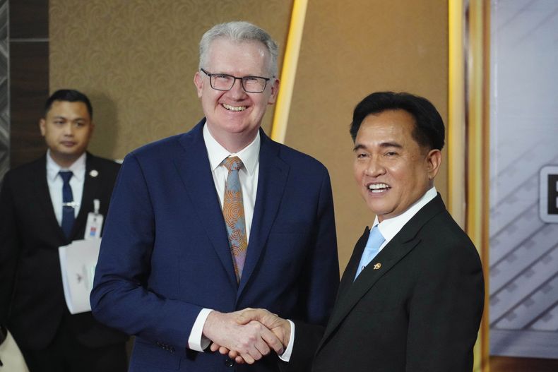 El ministro australiano del Interior, Tony Burke (izquierda), estrecha la mano del ministro coordinador indonesio de Asuntos Jurídicos, Derechos Humanos, Inmigración y Asuntos Penitenciarios, Yusril Ihza Mahendra, durante su reunión en Yakarta, Indonesia, el martes 3 de diciembre de 2024. (Foto AP/Tatan Syuflana)