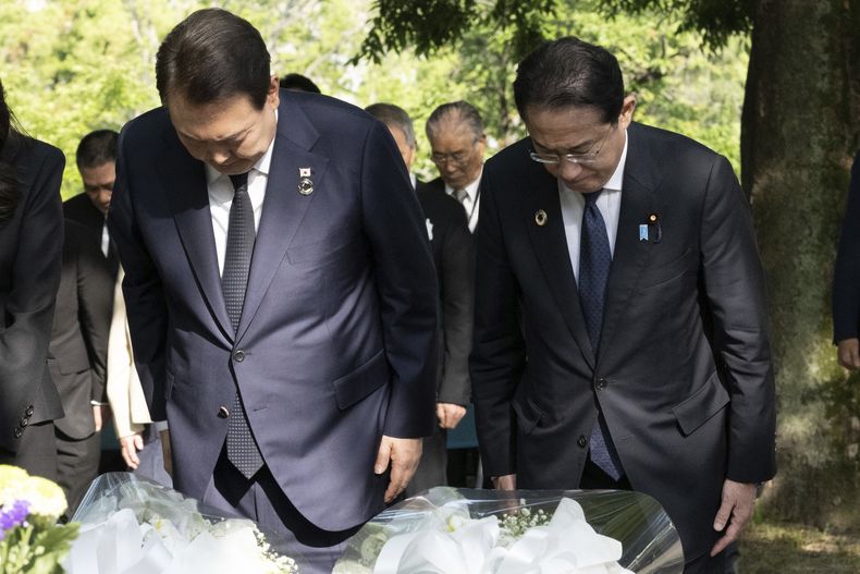 El presidente de Corea del Sur, Yoon Suk Yeol, a la izquierda, y el primer ministro de Japón, Fumio Kishida, hacen una reverencia después de dejar flores en el Monumento en Memoria de las Víctimas Coreanas de la Bomba Atómica, cerca del Parque de la Paz, el domingo 21 de mayo de 2023, en Hiroshima, Japón. (Yuichi Yamazaki/Pool Photo via AP)
