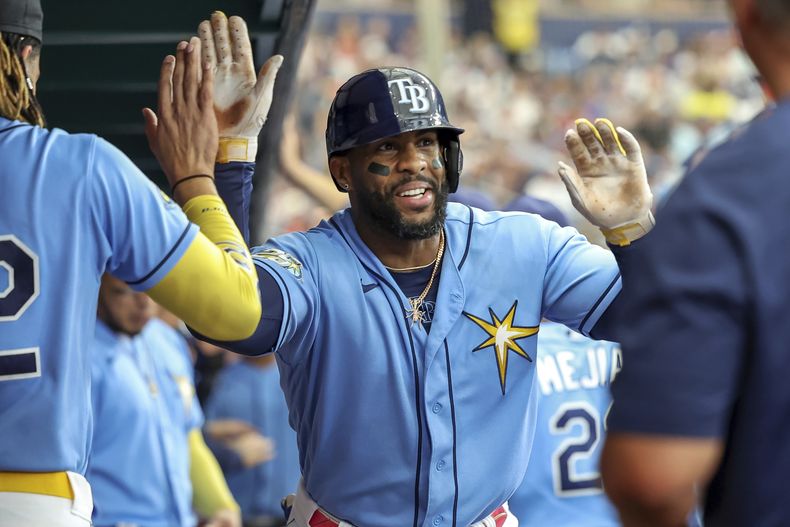 Yandy Díaz de los Rays de Tampa es felicitado por sus compañeros tras su cuadrangular de dos carreras ante los Bravos de Atlanta en el cuarto episodo del juego en San Petersburgo, Florida. Domingo 9 de julio de 2023. (AP Foto/Mike Carlson)