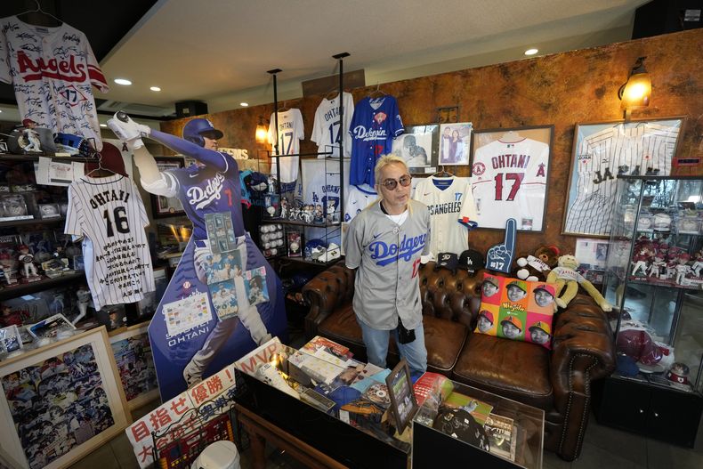 Hironobu Kanno, representante de un privado club de fans del pelotero japonés Shohei Ohtani de los Dodgers de Los Ángeles, muestra su colección de artículos relacionados al pelotero en su salón de belleza en Oshu, Japón el martes 29 de octubre del 2024. (AP Foto/Eugene Hoshiko)