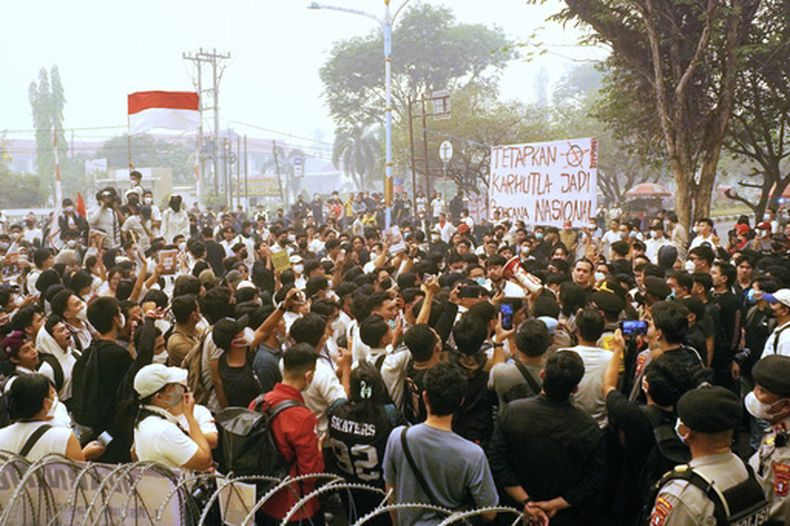 Un grupo de personas despliega un cartel que dice “Declaren los incendios forestales como desastre nacional”, durante una marcha en protestas contra la respuesta del gobierno indonesio ante la neblina tóxica derivada de incendios forestales que ha cubierto distintas ciudades, en Palangkaraya, Kalimantan Central, Indonesia, el viernes 23 de octubre de 2026. (AP Foto/Dias Gustrian)