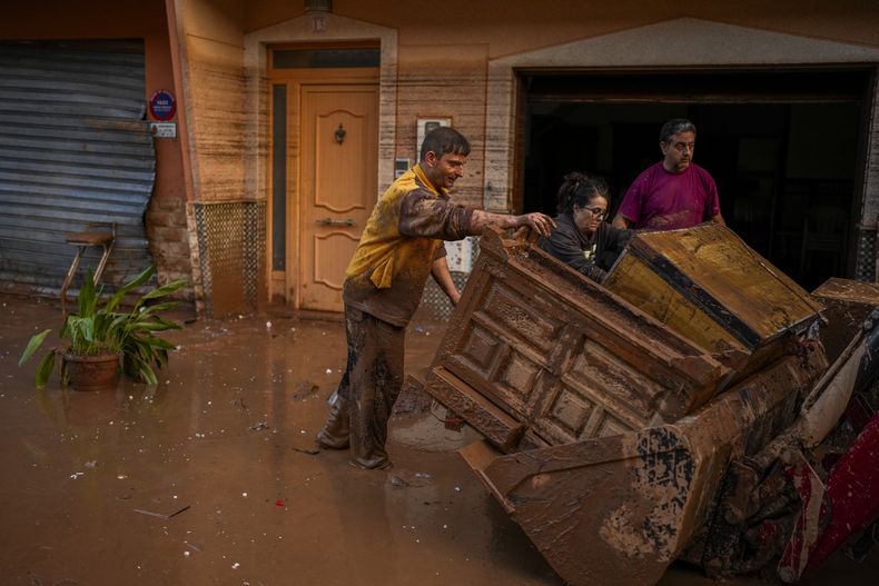 Personas limpian sus viviendas afectadas por las inundaciones en Utiel, España, el miércoles 30 de octubre de 2024. (AP Foto/Manu Fernández)