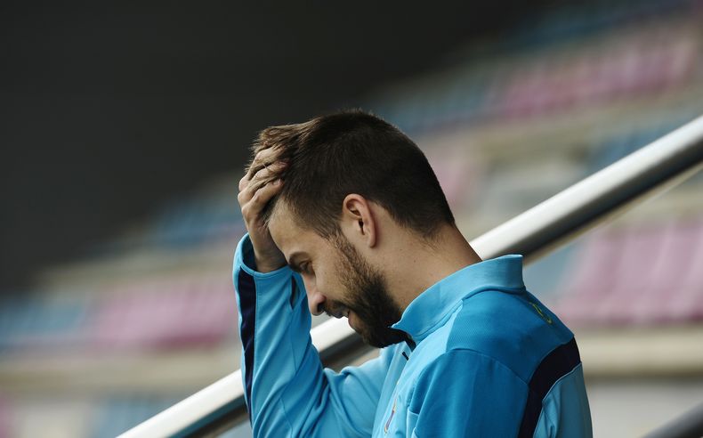 El jugador del Barcelona, Gerard Piqu&eacute;, se toca la cabeza durante un entrenamiento el s&aacute;bado, 22 de marzo de 2014, en San Joan Despi, Espa&ntilde;a. (AP Photo/Manu Fernandez)