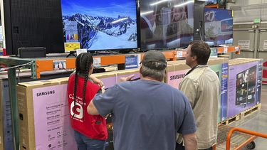 Una pareja de clientes analizan un televisor de gran tamaño con la ayuda de un socio de ventas en un almacén de Costco el jueves 1 de mayo de 2025, en Sheridan, Colorado. (AP Foto/David Zalubowski)