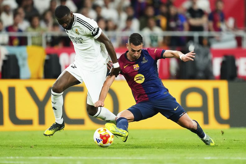 Antonio Rudiger (izquierda) del Real Madrid pugna por el balón con Ferran Torres del Barcelona en la final de la Copa del Rey, el domingo 27 de abril de 2025, en Sevilla. (AP Foto/José Bretón)