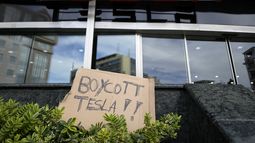 Un cartel es evidencia del descontento hacia Tesla, en un concesionario de esos vehículos en Lisboa el 9 de marzo del 2025. (AP foto/Armando Franca)