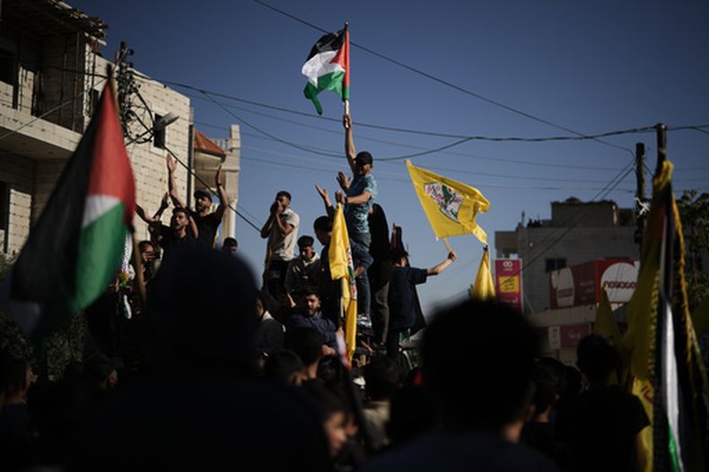 Dolientes ondean banderas palestinas y de Fatah durante el funeral de Awda Awawdeh, quien fue asesinado por colonos israelíes en la ciudad de Deir Dibwan, en Cisjordania, el jueves 23 de abril de 2026. (Foto AP/Leo Correa)