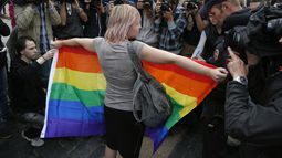 Una activista por los derechos de los homosexuales de pie con una bandera del arcoíris, frente a los periodistas, durante una protesta en la plaza Dvortsovaya, en San Petersburgo, Rusia, el 2 de agosto de 2015. (Foto AP, Archivo)