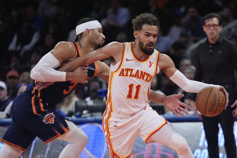 Trae Young (11), de los Hawks de Atlanta, lleva el balón rumbo a la canasta superando a Josh Hart (3), de los Knicks de Nueva York, durante la primera mitad del juego de baloncesto de la NBA Cup, el miércoles 11 de diciembre de 2024, en Nueva York. (AP Foto/Frank Franklin II)