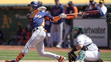 El dominicano Jeremy Peña, de los Astros de Houston, conecta un doblete adelante del cátcher Shea Langeliers, de los Atléticos de Oakland, en el juego del sábado 27 de mayo de 2023 (AP Foto/Jeff Chiu)