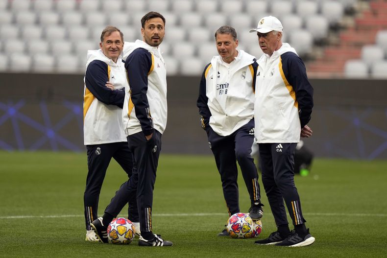 ARCHIVO - El técnico del Real Madrid, Carlo Ancelotti, espera el inicio de un entrenamiento junto a su hijo y asistente Davide (2do de izquierda a derecha) el 29 de abril de 2024, en Múnich (AP Foto/Matthias Schrader, archivo)