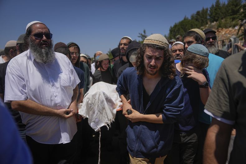 Dolientes cargan el cuerpo de Nachman Mordoff, de 17 años, durante su funeral en el asentamiento cisjordano israelí de Shilo, el miércoles 21 de junio de 2023. Mordoff estaba entre cuatro israelíes asesinados por dos palestinos que dispararon el martes contra un restaurante y una gasolinera cerca del asentamiento israelí de Eli, en Cisjordania. (AP Foto/Ohad Zwigenberg)
