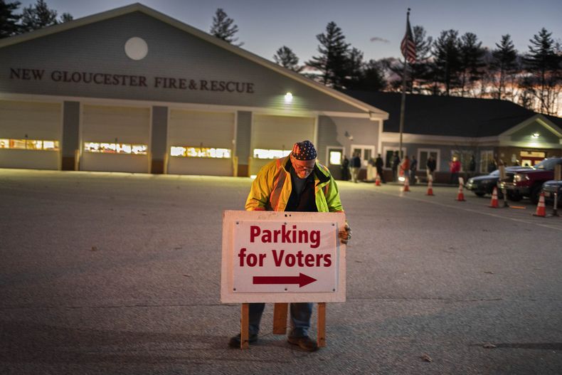 ARCHIVO - Roy McPhail coloca un carcel poco antes de que se abran las puertas a los votantes a las 6:00 a.m. en una estación de bomberos, el martes 8 de noviembre de 2022, en New Gloucester, Maine. (AP Foto/Robert F. Bukaty, Archivo)