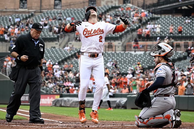 Gunnar Henderson (2) de los Orioles de Baltimore celebra su jonrón frente al receptor de los Astros de Houston, el dominicano Yainer Díaz, a la derecha, durante la primera entrada de un juego de béisbol, el domingo 24 de agosto de 2025, en Baltimore. (AP Photo/Nick Wass)
