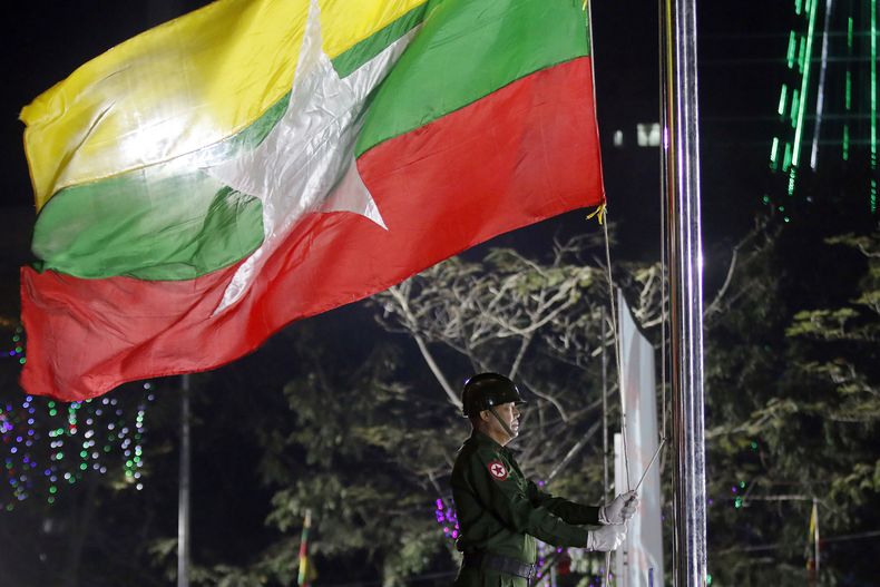 ARCHIVO- Un soldado de Myanmar iza la bandera durante una ceremonia del Día de la Independencia, en Yangon, Myanmar, 4 de junio de 2017. (AP Foto)