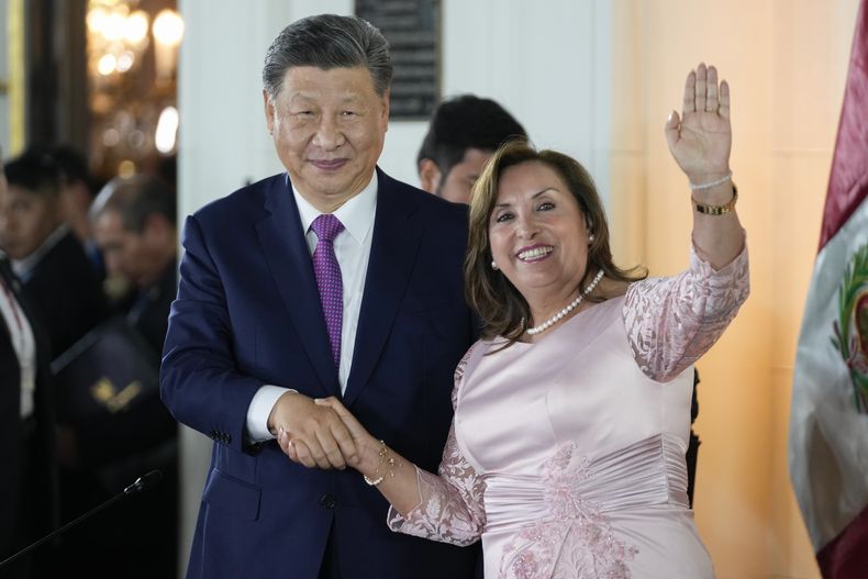 La presidenta de Perú, Dina Boluarte (derecha), y su homólogo chino, Xi Jinping, se estrechan la mano durante un acto para inaugurar virtualmente un puerto financiado por China en la ciudad de Chancay, en el palacio de gobierno en Lima, Perú, el 14 de noviembre de 2024. (AP Foto/Fernando Vergara)