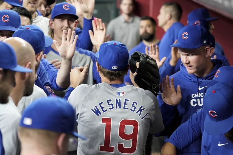El lanzador relevista de los Cachorros de Chicago, Hayden Wesneski (19), choca los cinco con sus compañeros de equipo después de ser retirado durante la novena entrada del juego de béisbol del equipo contra los Diamondbacks de Arizona el miércoles 17 de abril de 2024, en Phoenix. Wesneski lanzó cuatro entradas en blanco para que los Cachorros ganaran 5-3. (AP Foto/Darryl Webb)