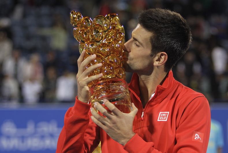 El serbio Novak Djokovic besa el trofeo tras vencer a David Ferrer en la final del torneo de Abu Dabi el s&aacute;bado, 28 de diciembre de 2013, en Abu Dabi. (AP Photo/Kamran Jebreili)