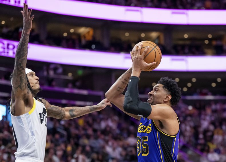 El alero de los Lakers de Los Ángeles, Christian Wood (35), va al aro contra el escolta del Jazz de Utah, Jordan Clarkson, a la izquierda, durante la primera mitad del partido de baloncesto de la NBA, el sábado 13 de enero de 2024, en Salt Lake City. (AP Foto/Spenser Heaps)