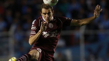americateve | Leandro Somoza del Lan&uacute;s de Argentina (arriba) disputa un bal&oacute;n con Juan Carlos Arce del Bol&iacute;var de Bolivia en los cuartos de final de la Copa Libertadores el jueves 15 de mayo de 2014. (AP Foto/Juan Karita)