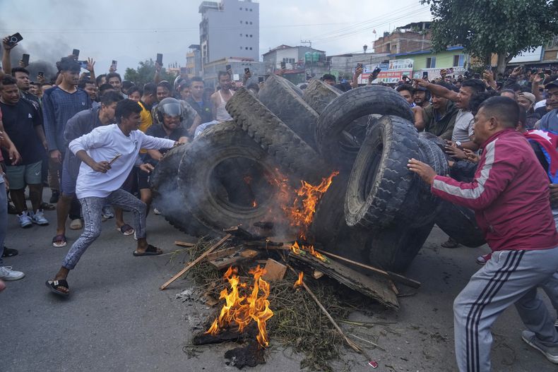 Manifestantes queman neumáticos, incumpliendo el toque de queda en Katmandú, Nepal, el martes 9 de septiembre de 2025. (AP Foto/Niranjan Shrestha)
