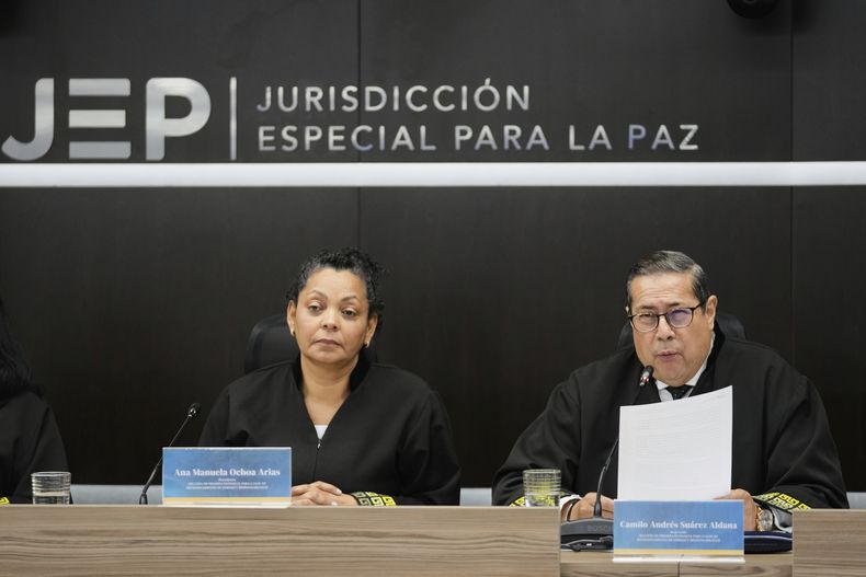 Camilo Andrés Suárez, a la derecha, y Ana Manuela Ochoa, miembros del tribunal de paz de Colombia, leen una sentencia por crímenes de guerra contra ex líderes de las Fuerzas Armadas Revolucionarias de Colombia (FARC) en Bogotá, Colombia, el martes 16 de septiembre de 2025. (AP Foto/Fernando Vergara)