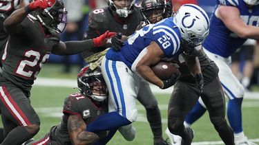 Antoine Winfield Jr. (31), safety de los Buccaneers de Tampa Bay, derriba a Jonathan Taylor (28), running back de los Colts de Indianápolis, durante la segunda mitad del juego de la NBA, el domingo 26 de noviembre de 2023, en Indianápolis. (AP Foto/Darron Cummings)
