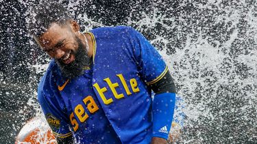 El dominicano Teoscar Hernández, de los Marineros de Seattle es empapado con la hielera tras batear el hit decisivo en el encuentro de viernes 21 de julio de 2023, ante los Azulejos de Toronto (AP Foto/Lindsey Wasson)