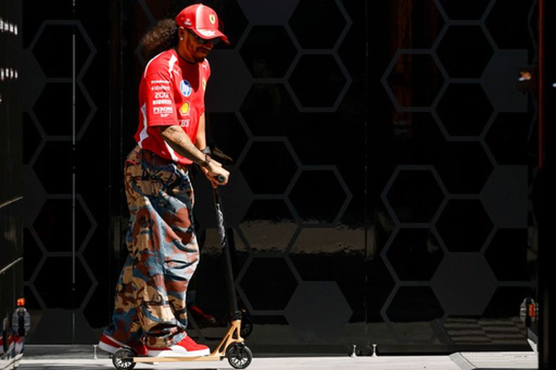 El británico Lewis Hamilton de Ferrari conduce un scooter en los pits del Gran Premio de Barcelona-Catalunya el jueves 11 de junio del 2026. (AP Foto/ Joan Monfort)