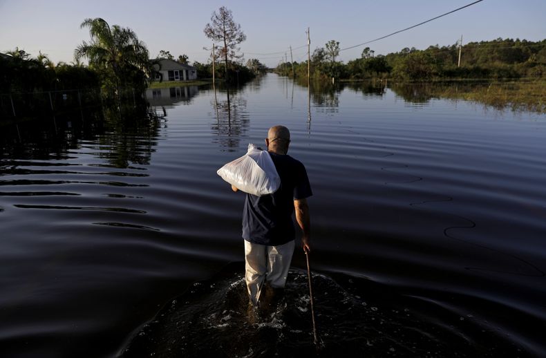 Jean Chatelier camina por una calle inundada luego del huracán Irma, en Fort Myers, Florida, el 12 de septiembre del 2017. (AP foto/David Goldman)