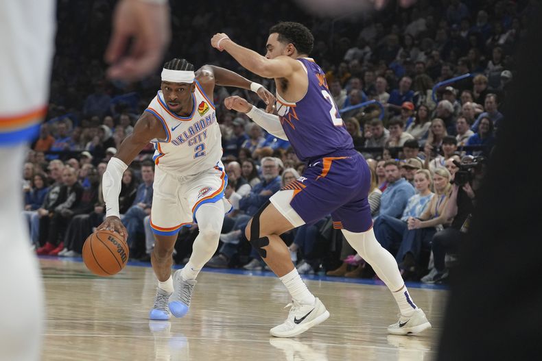 Shai Gilgeous-Alexander, del Thunder de Oklahoma City, avanza frente a Tyus Jones, de los Suns de Phoenix, el miércoles 5 de febrero de 2025 (AP Foto/Kyle Phillips)